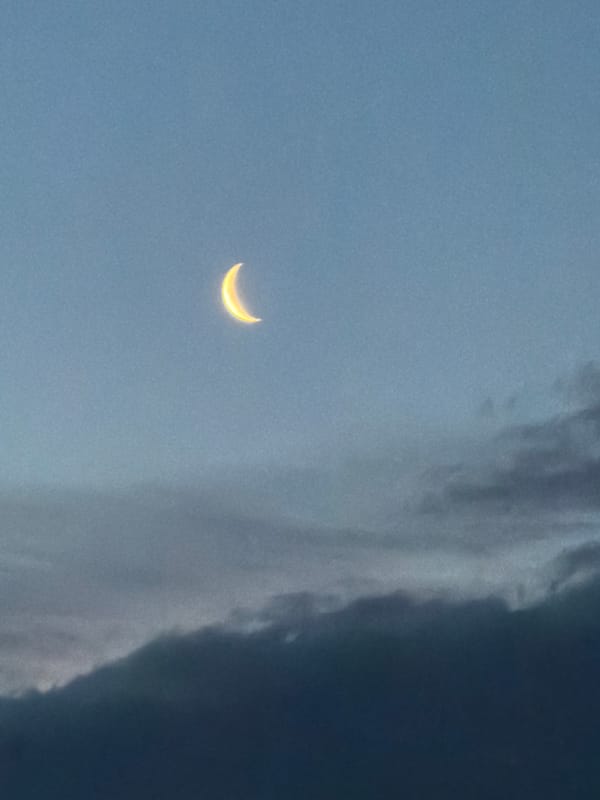 Crescent moon photographed through clouds in Luxembourg early morning