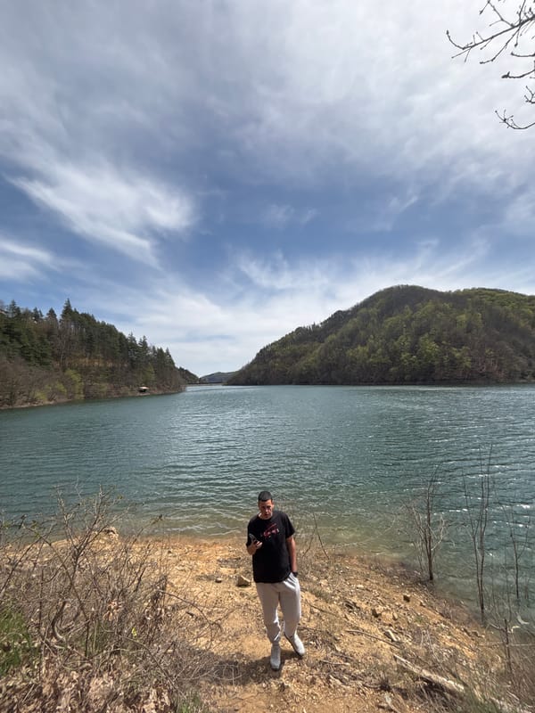 Man stands by lake shore in Alamovtsi, Bulgaria