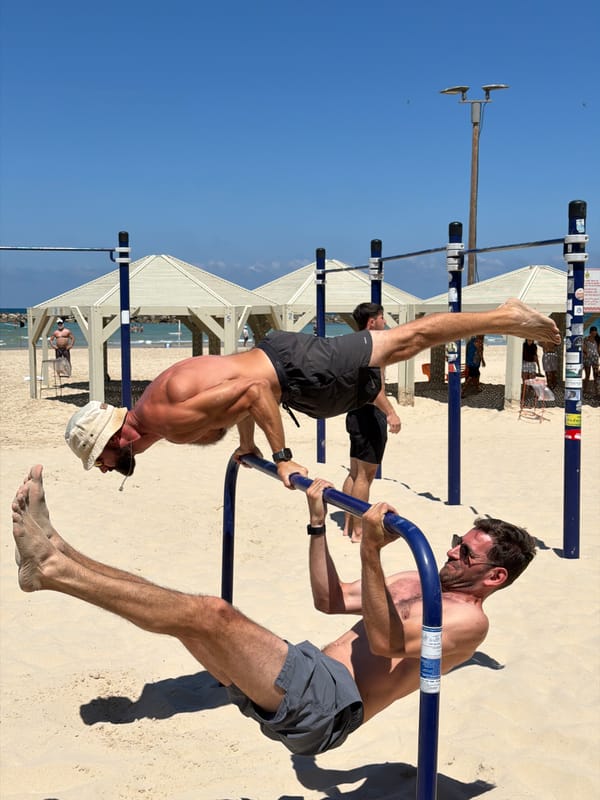 Two men use blue equipment on Tel Aviv beach