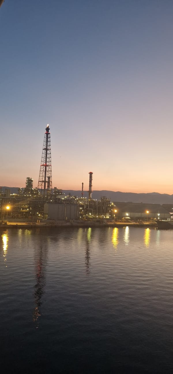 Industrial waterfront at dusk, sky painted in gradient hues