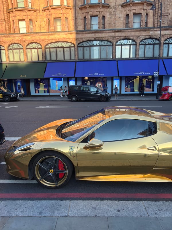 Gold Ferrari and Bentley draw attention on a London luxury street