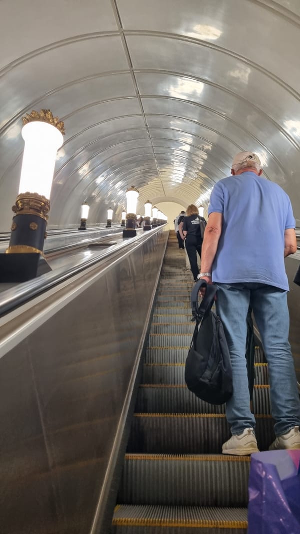 Metro escalator stretches upward in a busy transit station