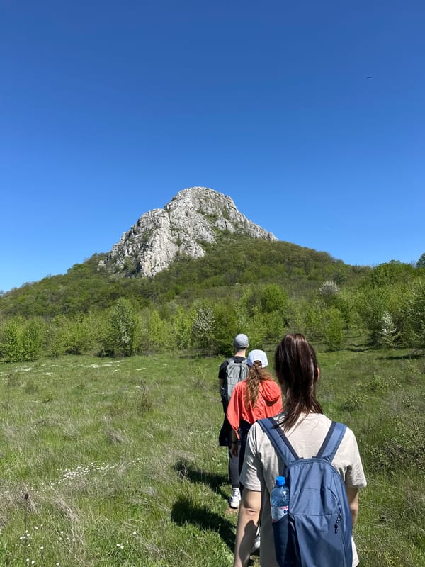 Three hikers traverse grassy field near Bilka, Bulgaria