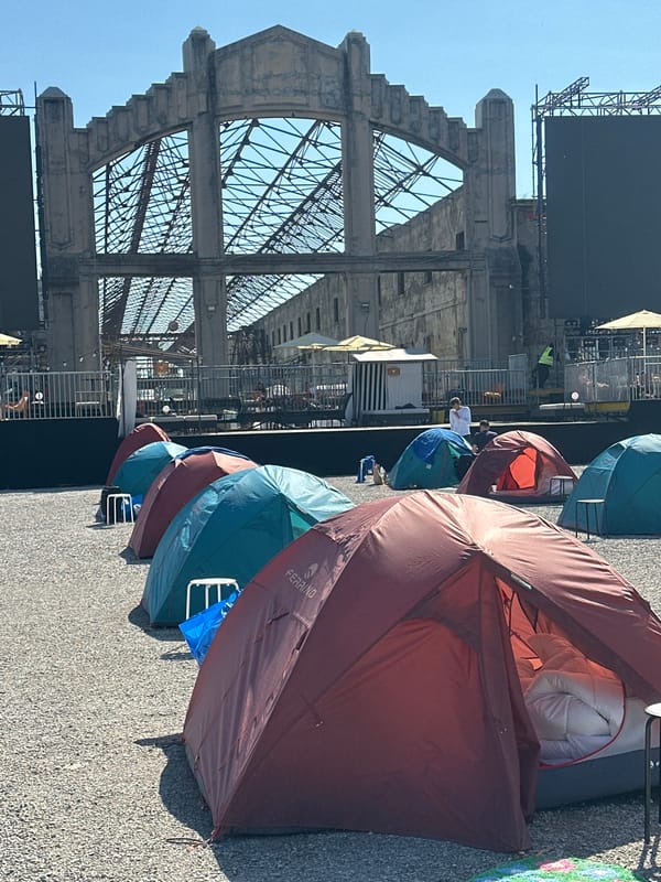 Camping tents with gear spotted on paved surface in Milan