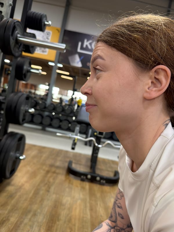 Woman performs barbell squats during gym workout session