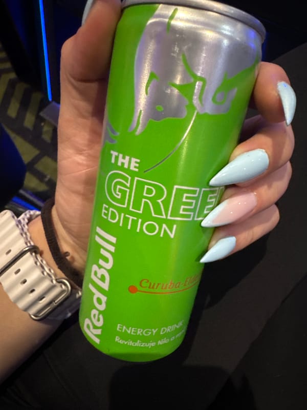 Person with blue nails, energy drink, velvet bag documented