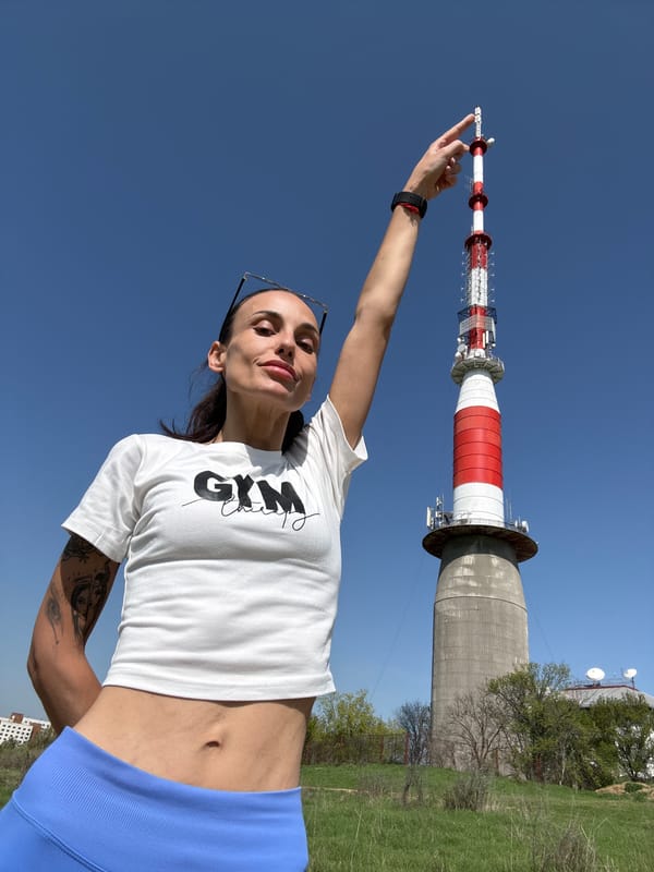 Woman poses playfully with communications tower in Pleven