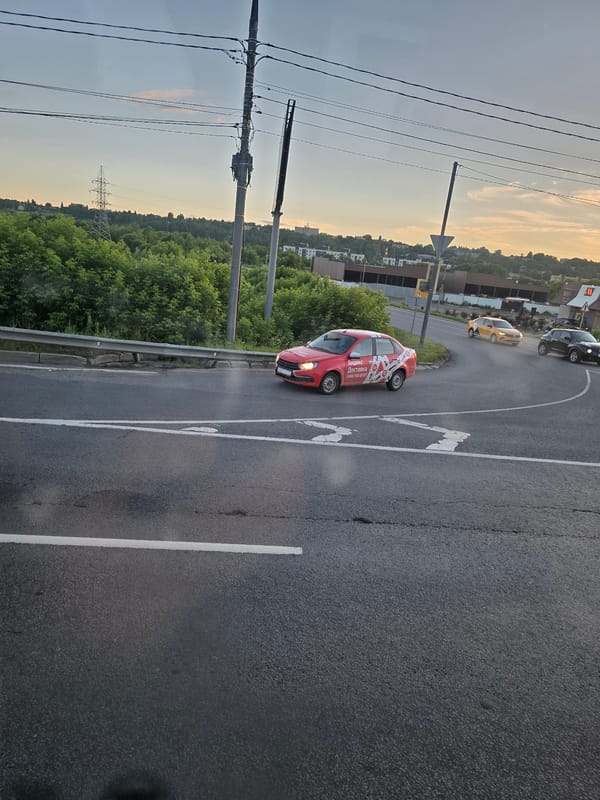 Dusk drive past a roadside McDonald's on wet urban streets