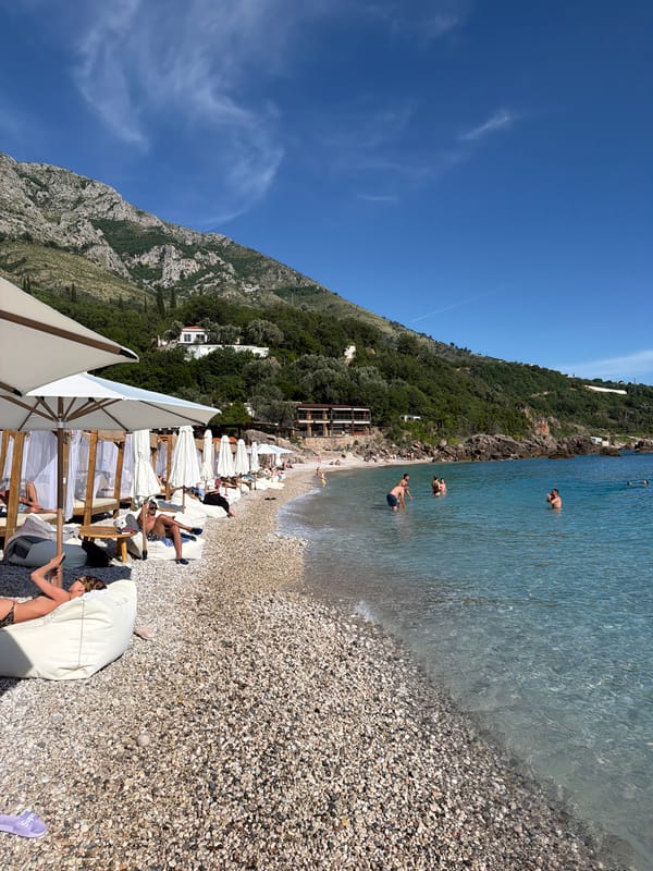 Beach activity at Sveti Stefan under clear skies