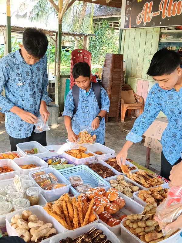 Young men gather around food table in Lhokseumawe