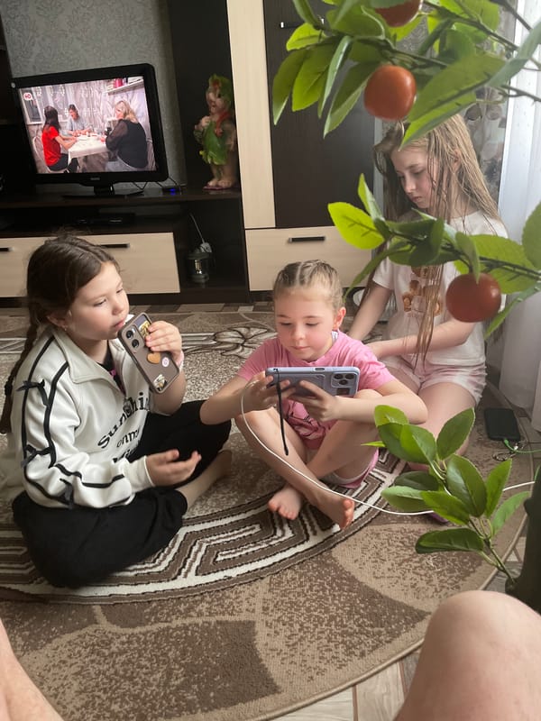 Children play indoors on rug in Nizhnii Bugrysh home