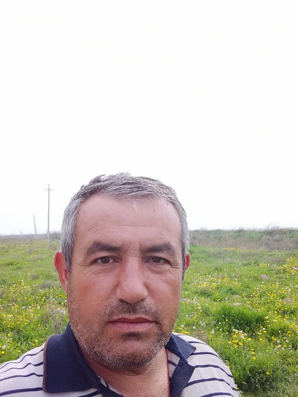 Man photographed in wildflower field in rural Uzbekistan