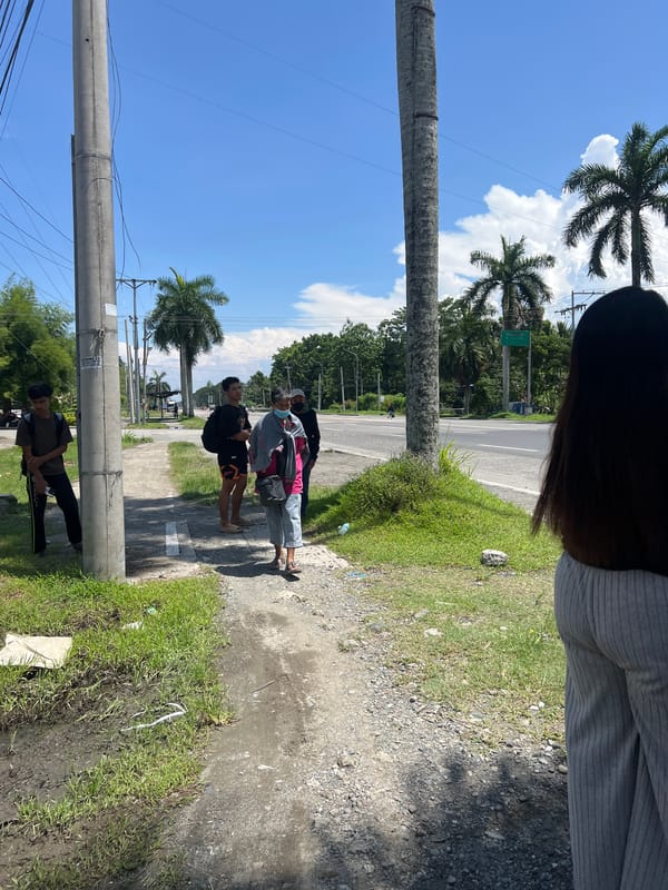 Yellow bus gathering documented on palm-lined Tagum road