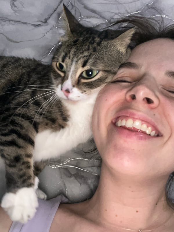 Woman enjoys quiet evening with cat watching TV in Russia