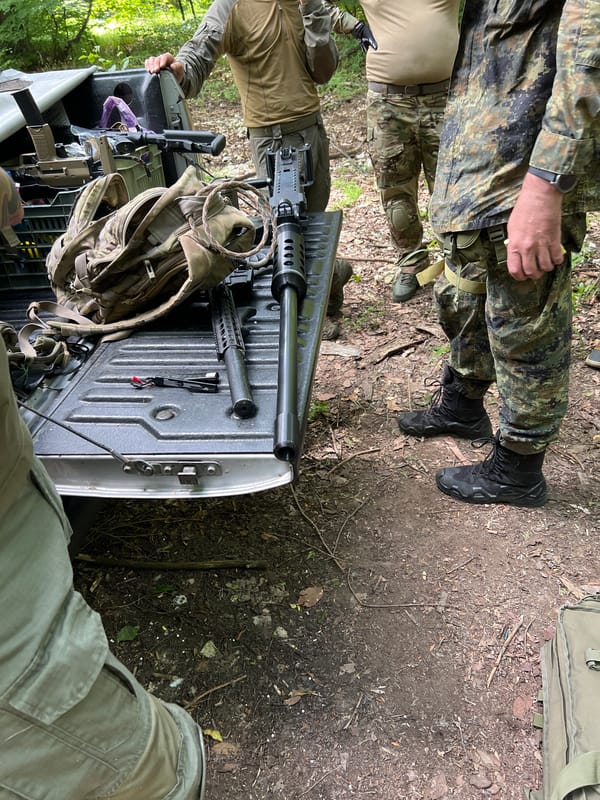 Armed individuals in tactical gear observed in wooded area