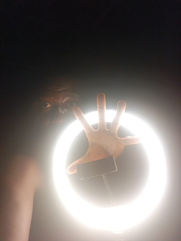 Person with face paint photographed under ring light