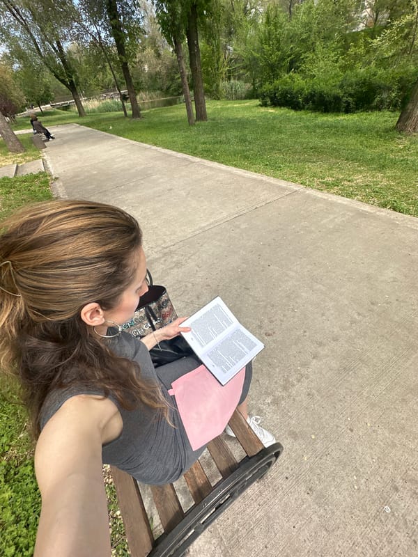 Woman reads book, eats lunch on park bench in Kryvyi Rih