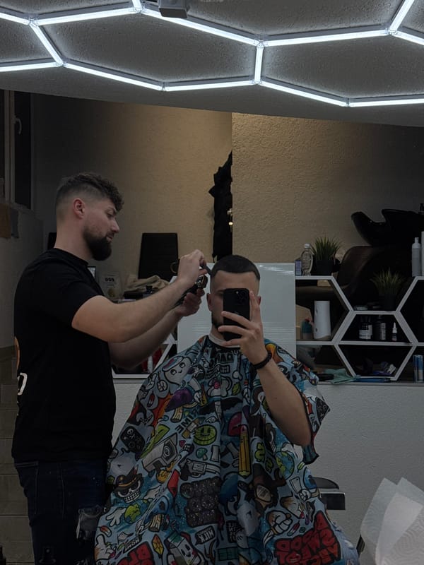 Barber cuts hair for smartphone-holding customer in Smolyan