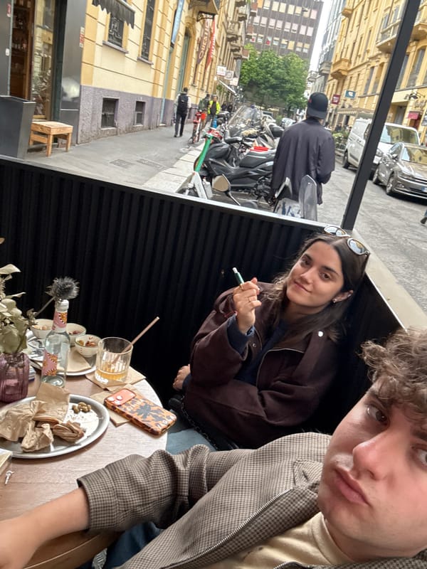 Two young people photographed at outdoor table in Milan
