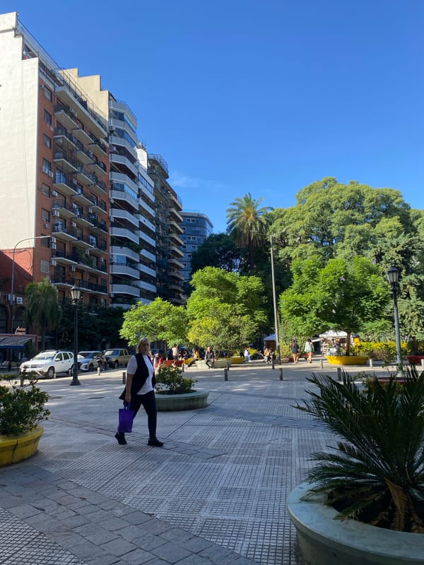 Woman walks past modern apartment building in Buenos Aires
