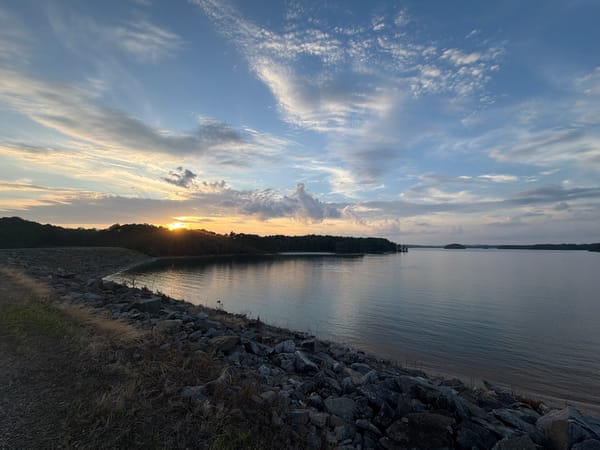 Lake Lanier glows at sunset from Sugar Hill's dam shore.