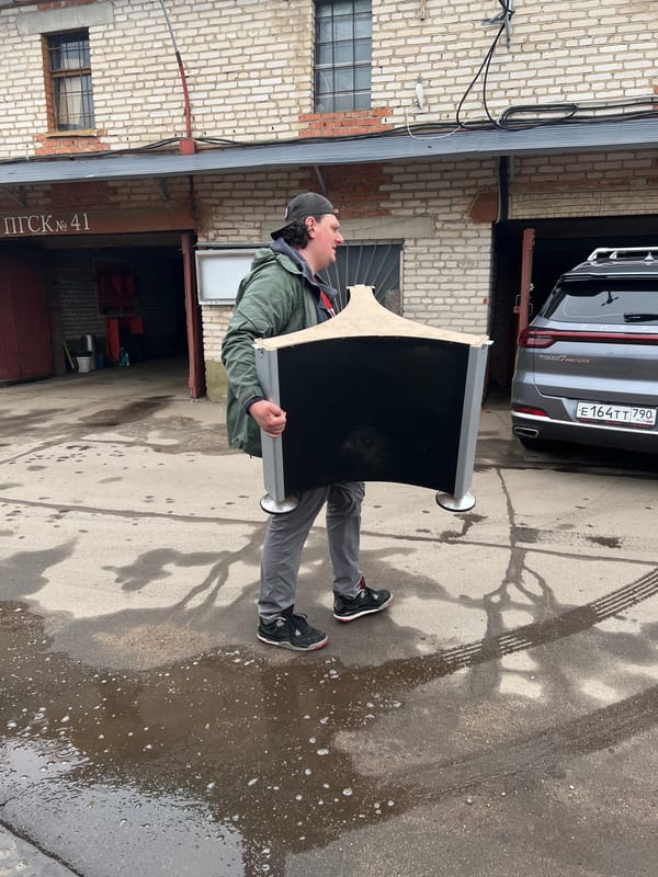 Men move wrapped object through Mytishchi garage complex