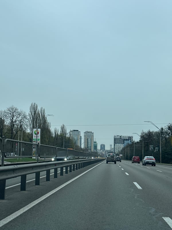 Morning traffic flows past modern architecture in Kyiv
