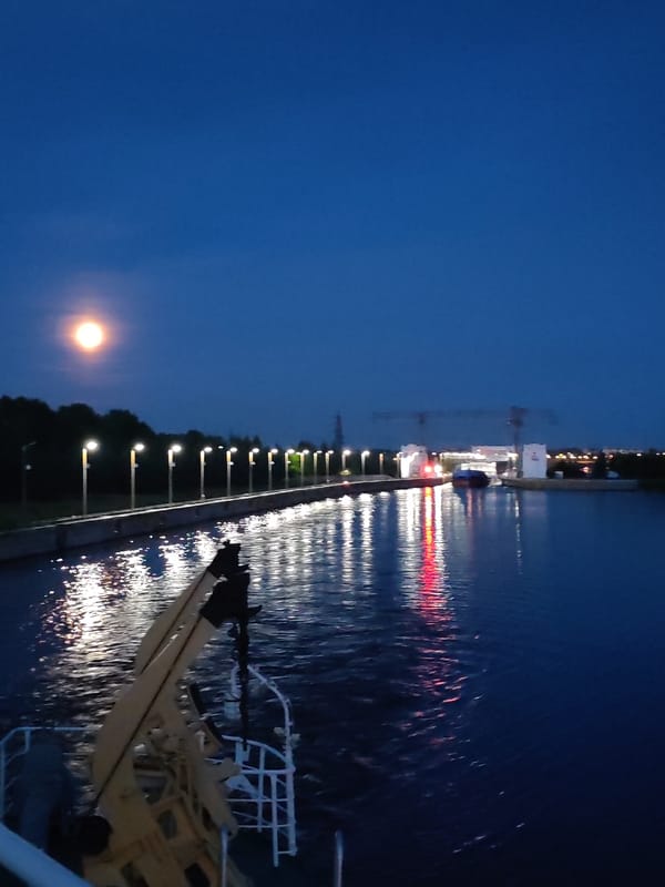 Twilight at the Sheksna River lock, cargo ships passing through