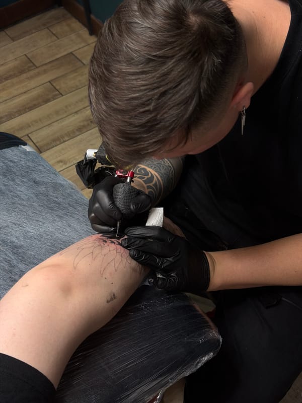 Tattoo artist works on client's arm design in Orenburg studio