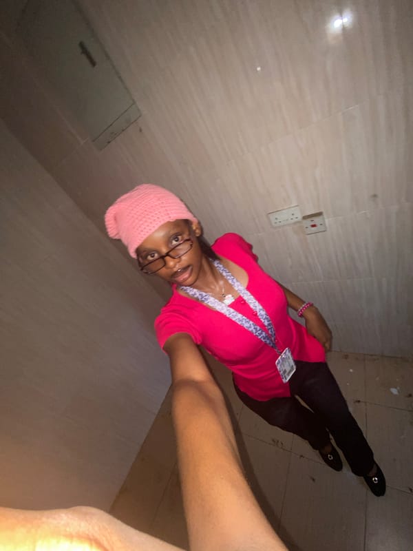 Person in pink beanie takes multiple selfies indoors