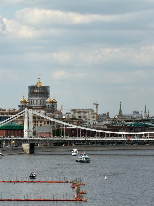 Tourist boat cruises Moscow River past cathedral renovation