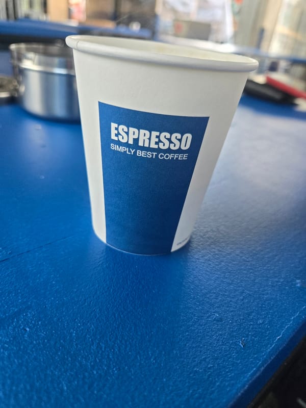 Coffee cup and lighter documented on blue surface