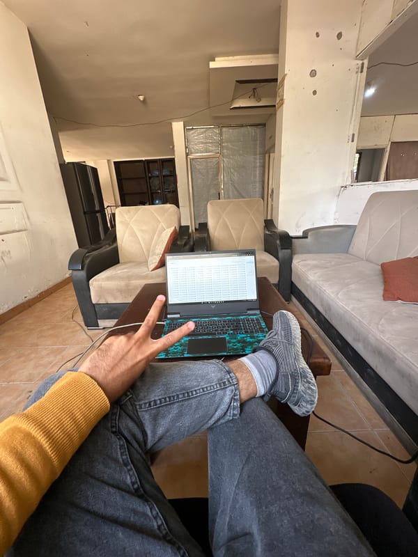 Person works on laptop, man rests on sofa in Gaza