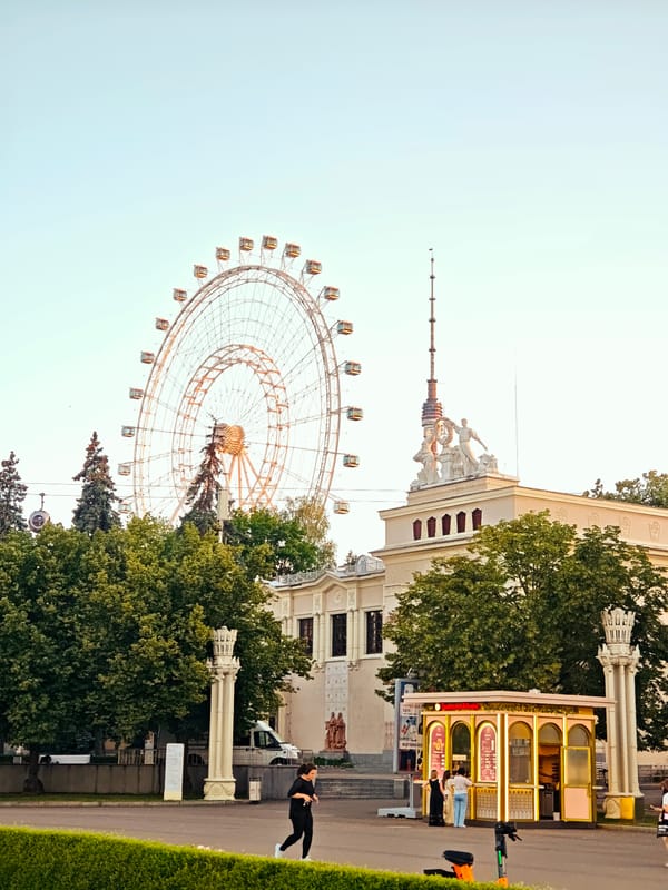 Golden hour at VDNKh: fountain and Ferris wheel at dusk