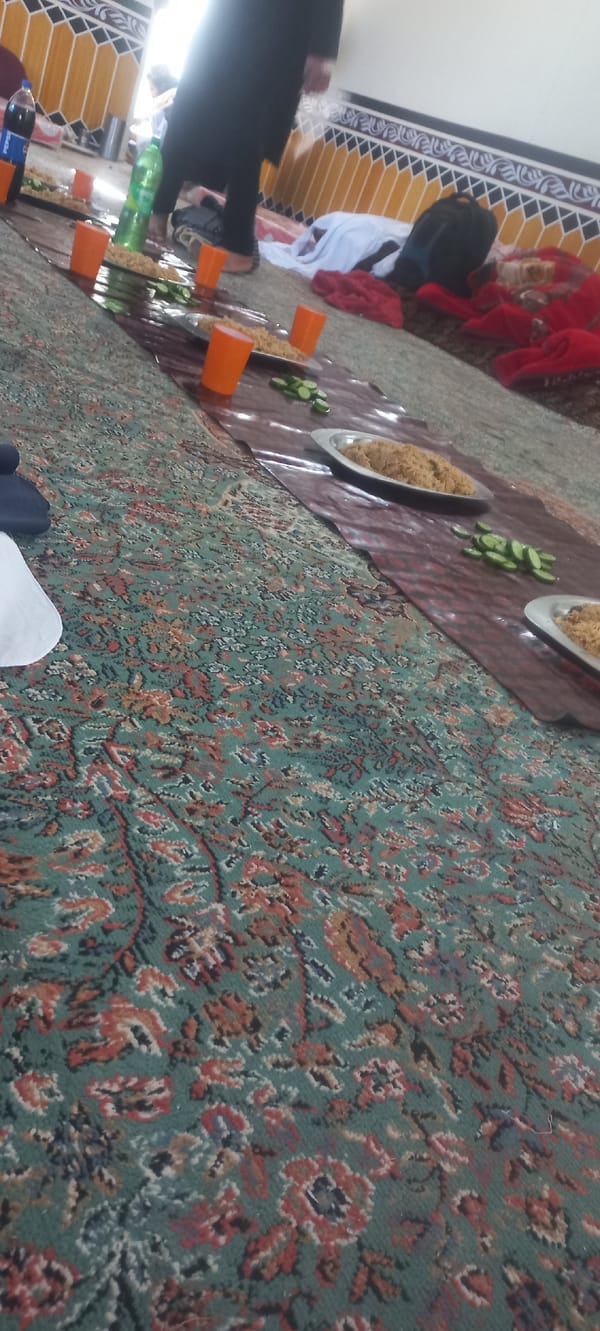 Three men share meal in Muhammad Khel, Pakistan