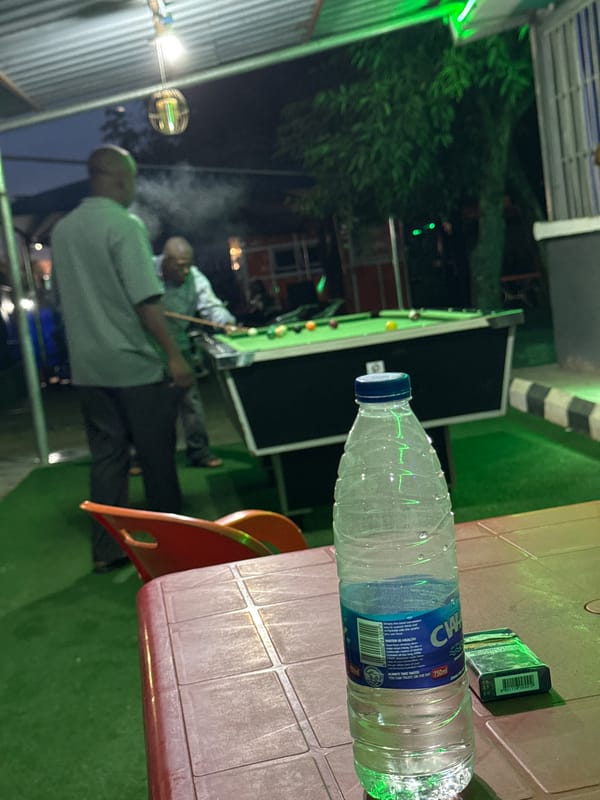 Men play nighttime billiards outdoors in Karu, Nigeria