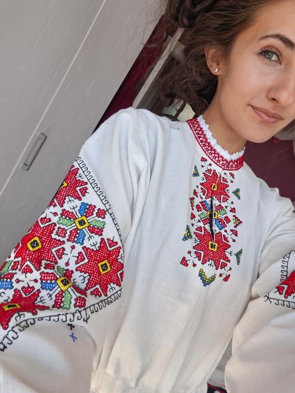 Traditional embroidered outfit and ornate headpiece on display