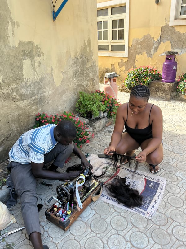 Outdoor sewing and textile work documented in Abuja neighborhood