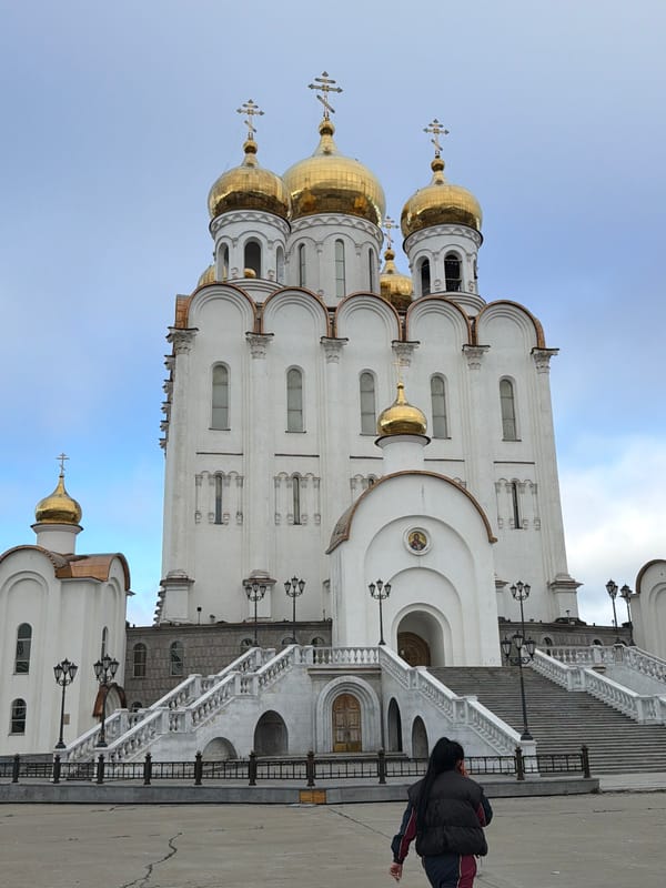 Orthodox church, bronze saint, and a seagull in Magadan