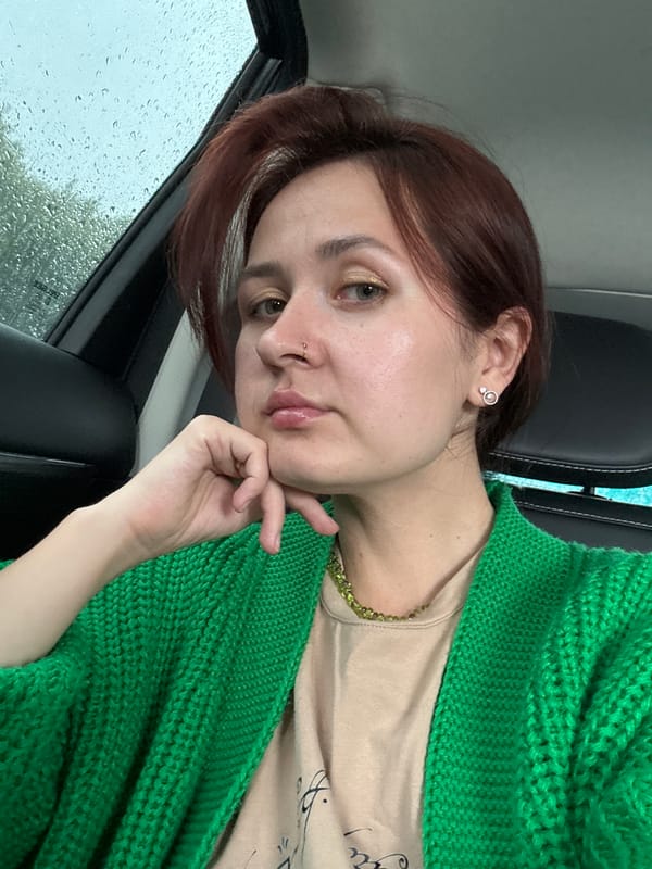 Inside a parked car in Naberezhnye Chelny, green cardigan and necklace