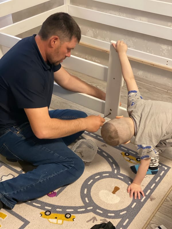 Father and child assemble furniture together in Sochi home