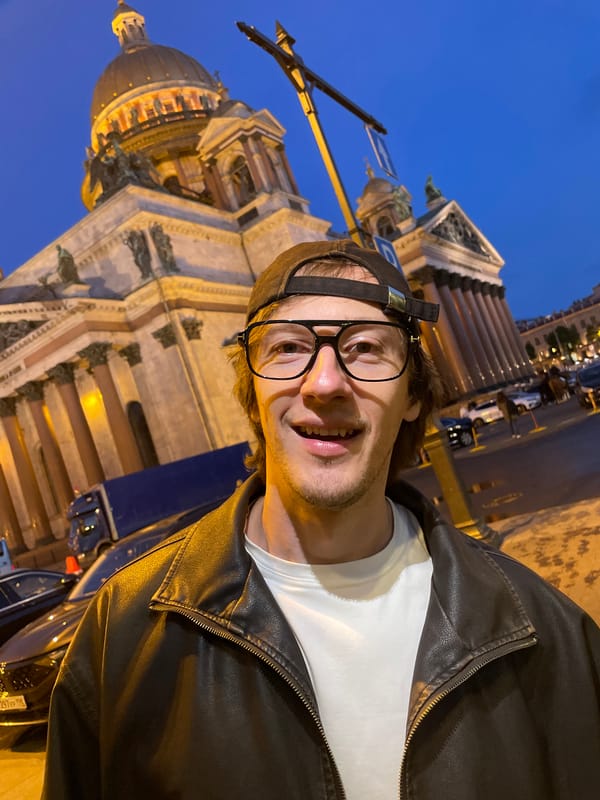 Tourists take selfies at St. Isaac's Cathedral at dusk