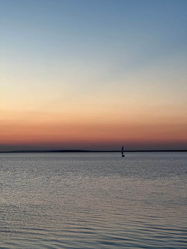 Sunset sailing on a calm Kazakhstan lake at dusk