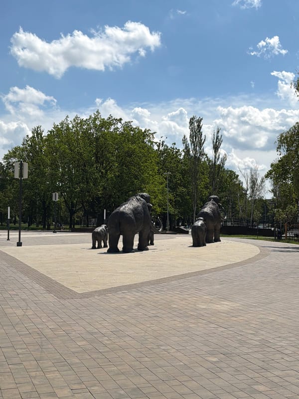 Kid explores a sunny urban park with elephant sculptures