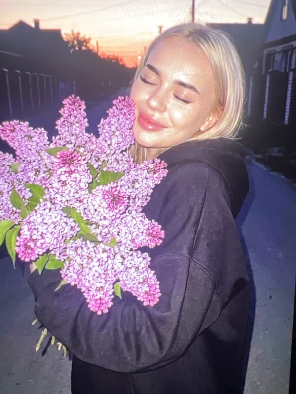 Woman photographed in serene outdoor portrait session with lilacs