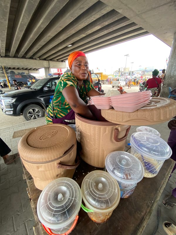 Street vendors conduct morning business under Lagos highway overpasses