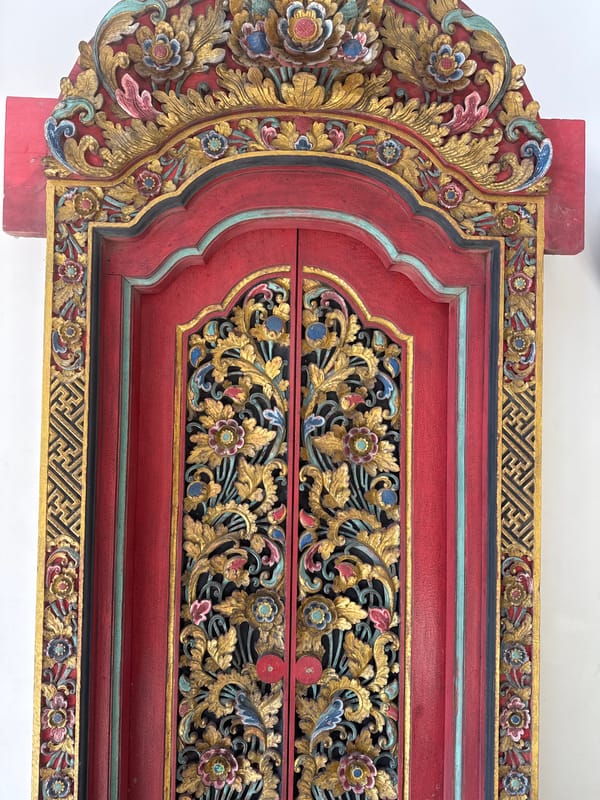 Balinese property details: carved doors, blooming frangipani, and bougainvillea