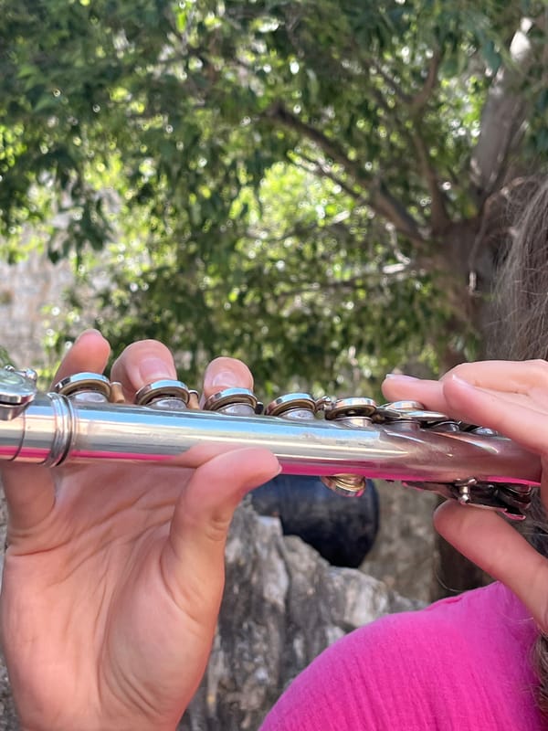 Street musician plays flute in historic Budva, Montenegro