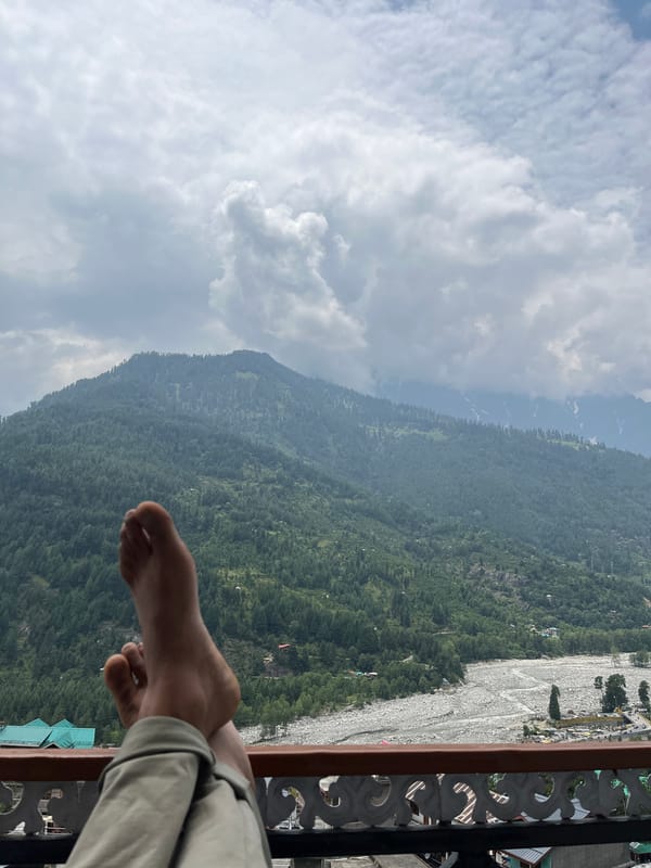 Feet up on a balcony railing, Vashisht mountain views