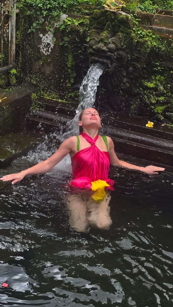 Tourists participate in purification rituals at Bali water temple